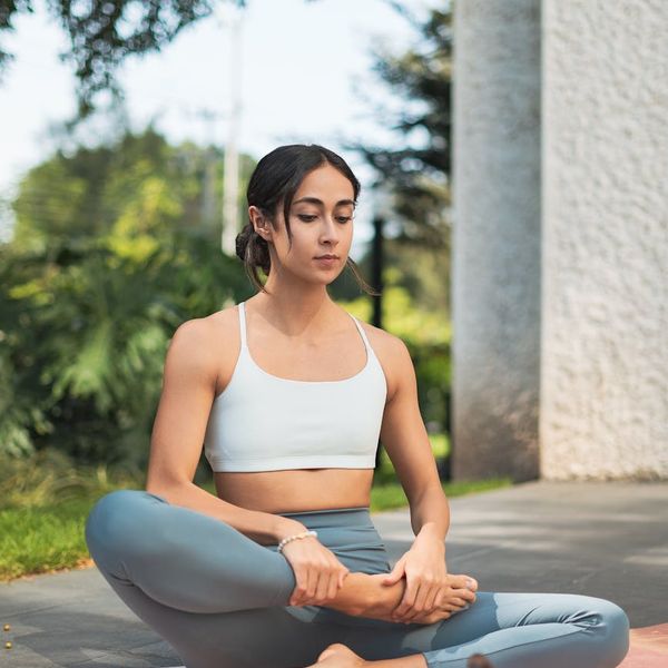 A serene person meditating in a calm, natural setting.